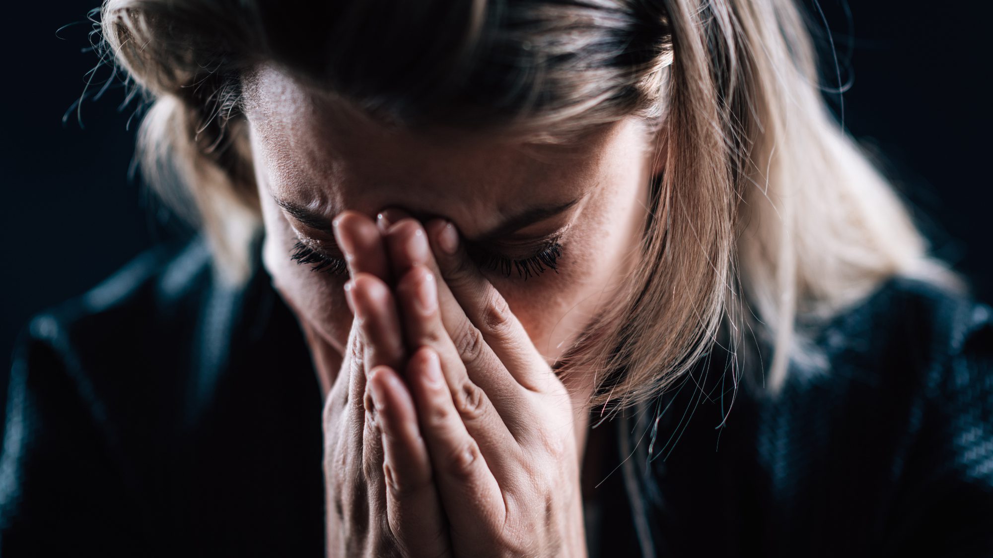 Anxious female face, portrait on a dark background